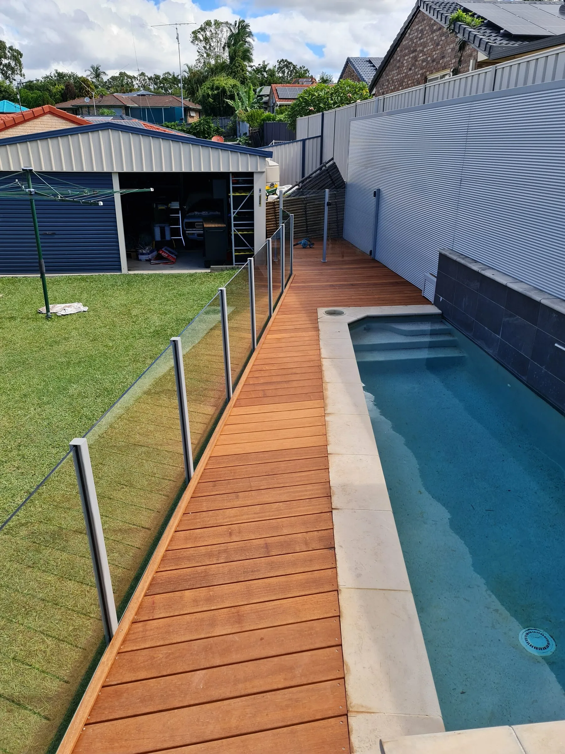 The finished hardwood pool surround, boards oiled and run the length of the pool to the glazed screen.