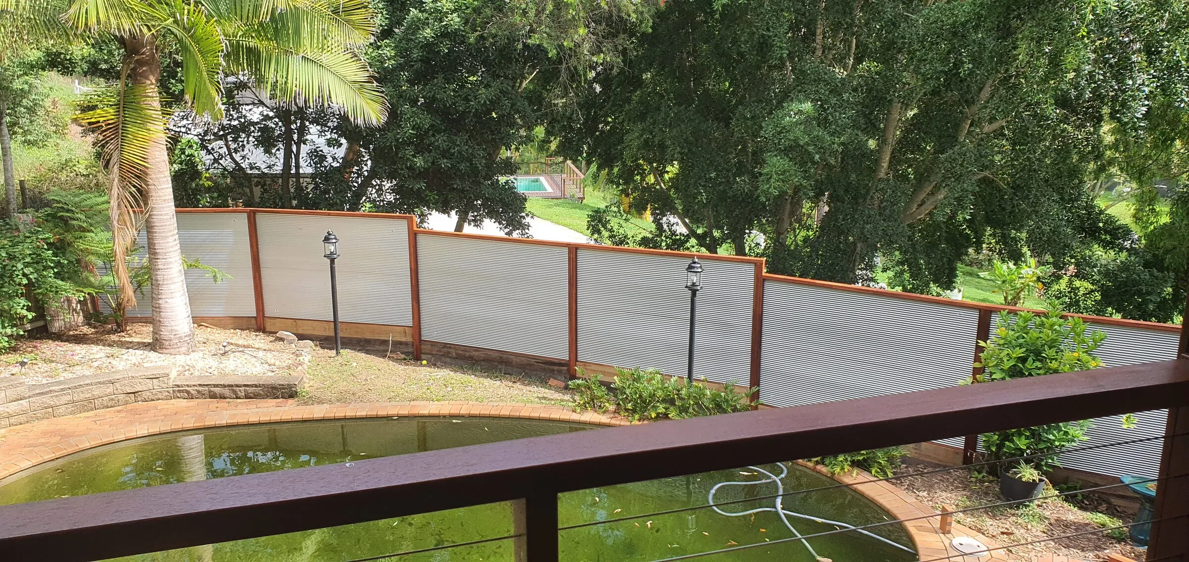 The same run of screen panels from the deck above, stepping down with the fall of the ground.