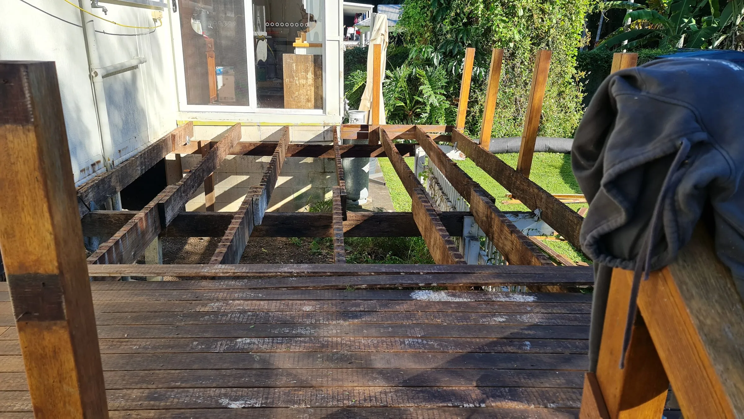 Boards stripped back to the joists, rot running along the bearers underneath.